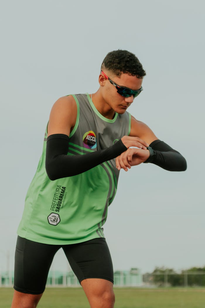 Male athlete in sportswear checking smartwatch in a park in Rio de Janeiro.
