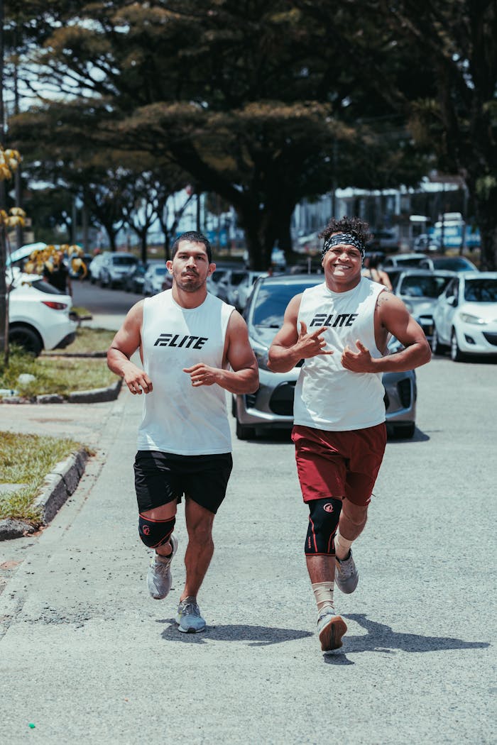 Two athletic men jogging on a city street in Pereira, Colombia on a sunny day.